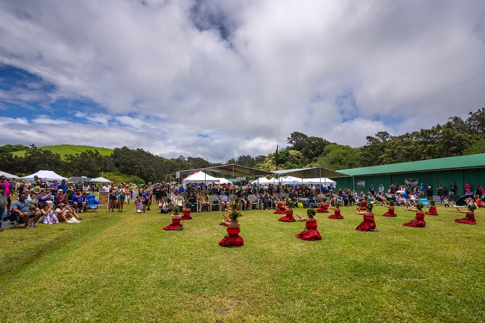 960-HAVO_20240720_Young dancers with Lori Leis Hula Studio-2_J.Wei Young hula dancers wearing red entertain a crowd outdoors