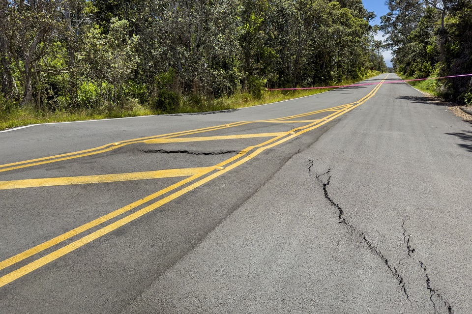 960-HAVO_20240727_Cracks and buckling on the Maunaulu access road_Y.Baur A paved road with yellow striping is cracked and buckled due to recent earthquake activity