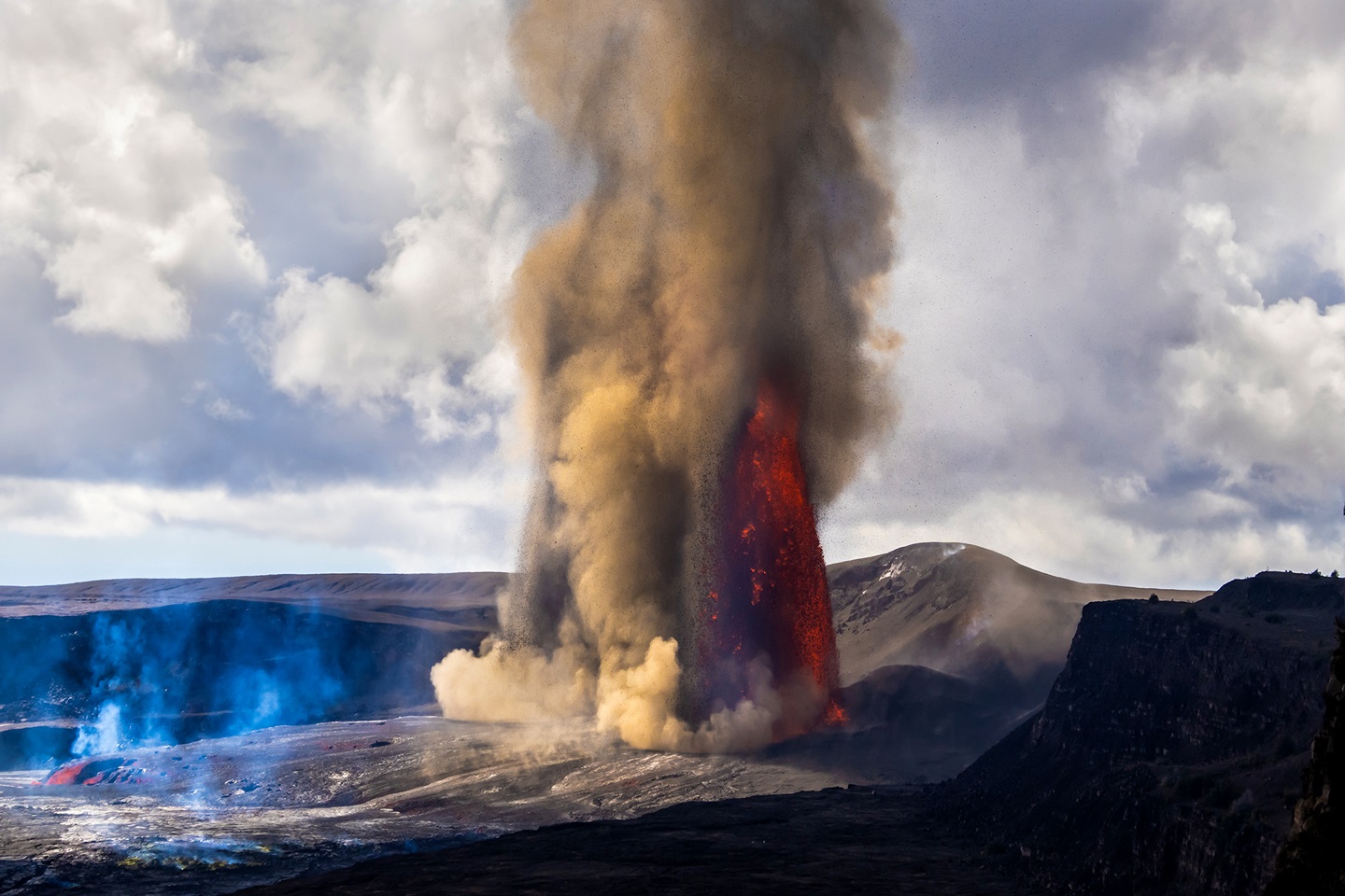 Lava fountains and plumes of gas and tephra erupt out of a volcano