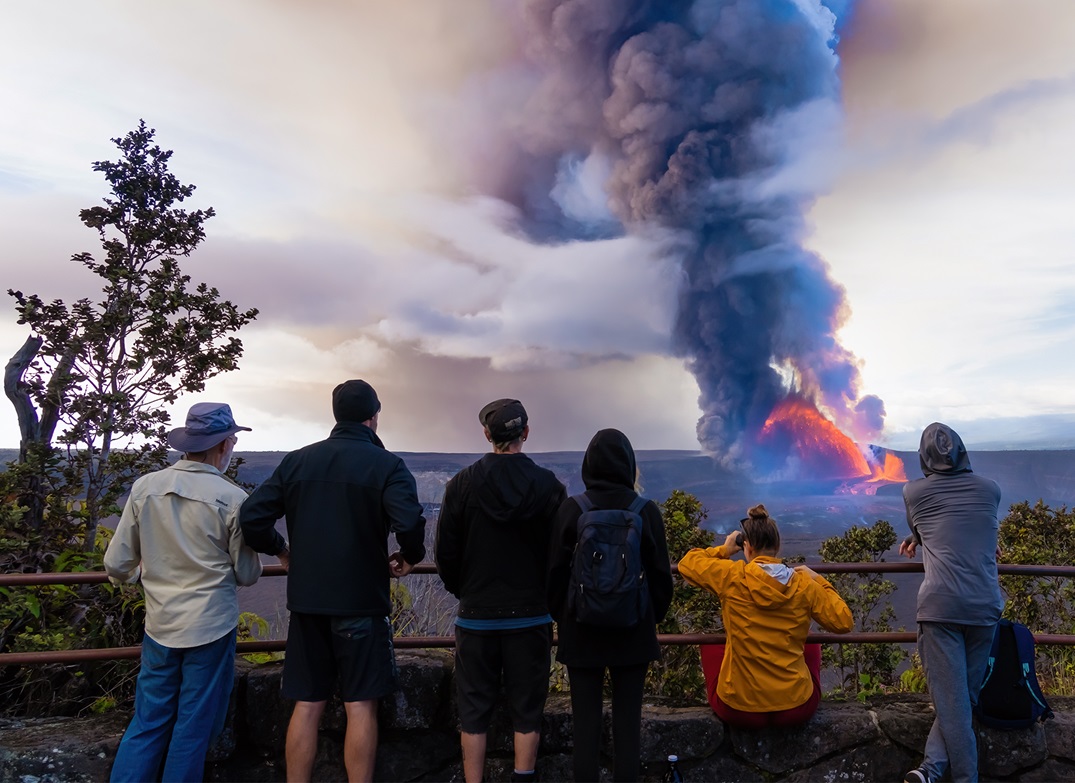 Visitors watch lava fountain from a volcano from a safe overlook