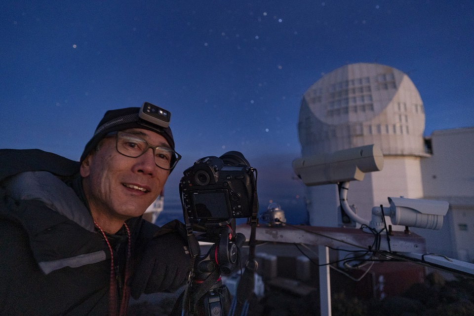 Artist in residence Stan Honda at Maunakea Night sky portrait of photographer Stan Honda near a space observatory on Mauna Kea volcano