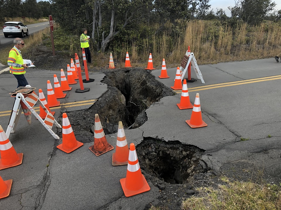 Workers contemplate earthquake damage to road Workers contemplate earthquake damage to road