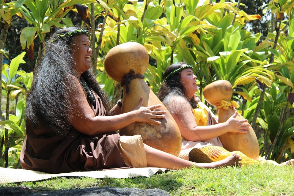 Performers of Hālau Hula Ulumamo o Hilo Palikū Two performers chant and pound gourds