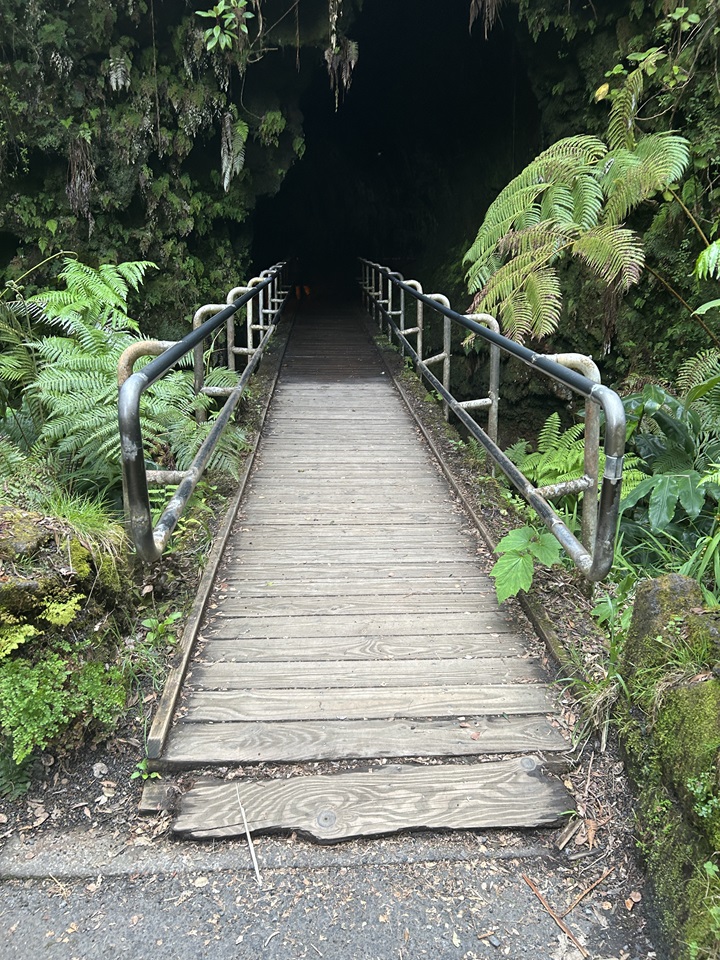 A worn out wooden bridge leading into a cave