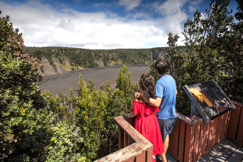 Puu Puai Overlook Couple gazes at Kīlauea Iki Trail below them from forested overlook above