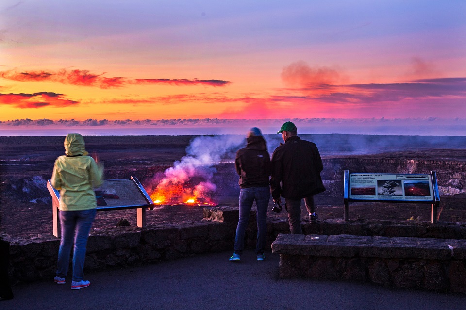 Visitors enjoy a rosy glow of sunrise and the glowing lava lake at Kīlauea summit