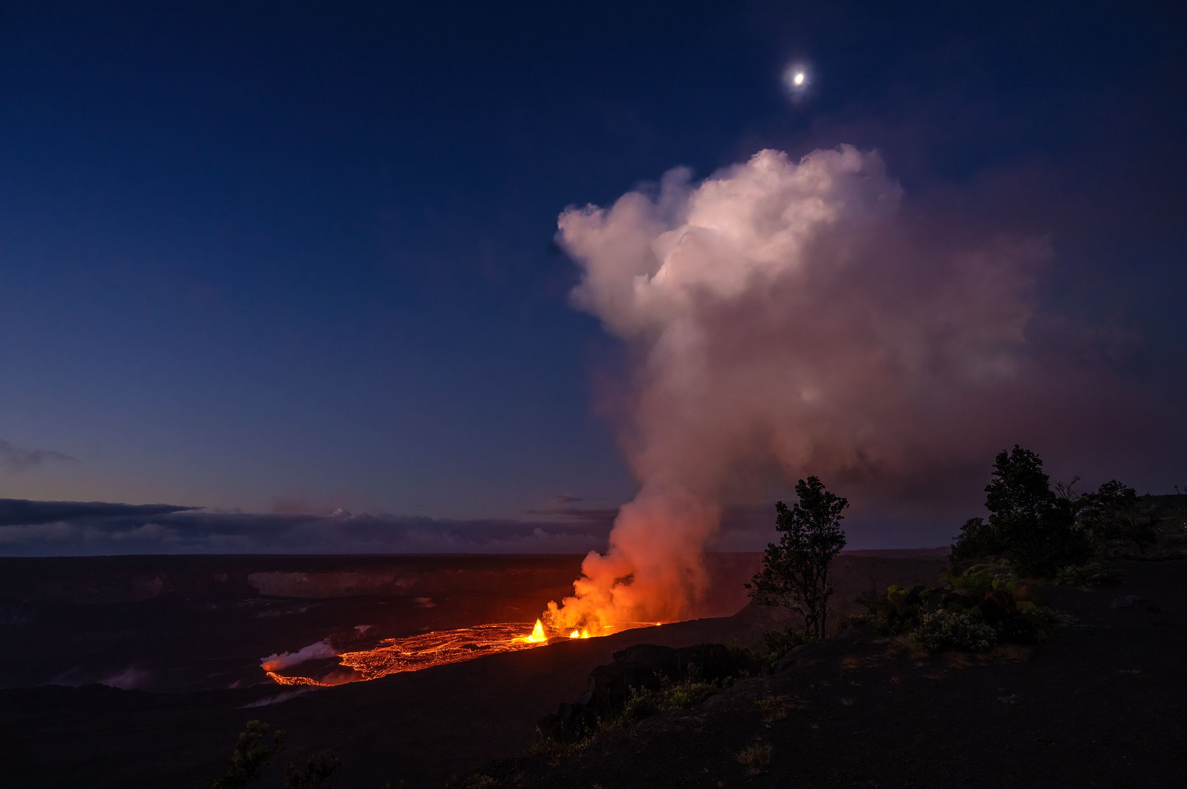 Lava erupting in a crater at night.