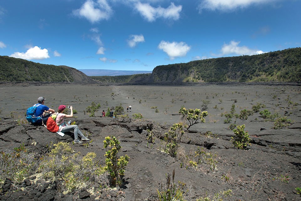 Park visitors stop for a rest and a photo opportunity on Kīlauea Iki Trail