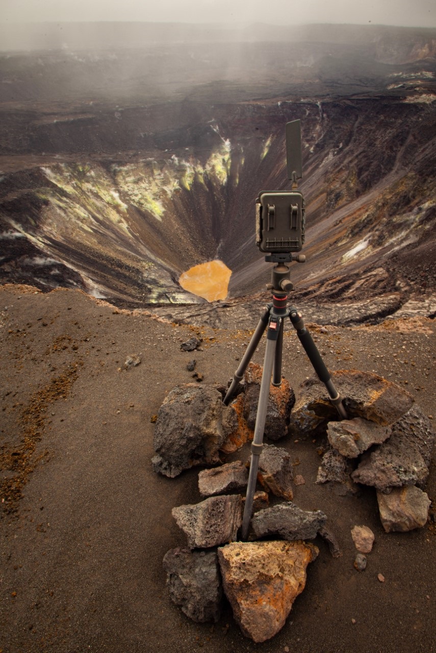 A body of water in a steep volcanic crater wioth a web cam positioned above it