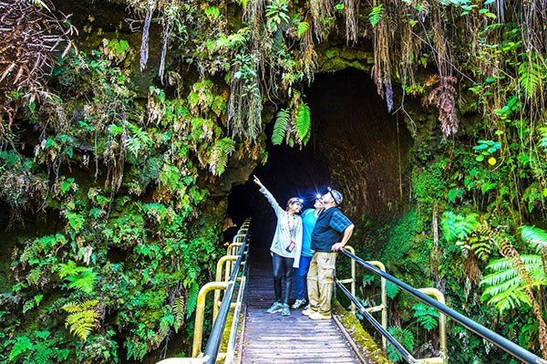 A prepared family wearing headlamps prepares to enter the Nāhuku during its dark, natural state A prepared family wearing headlamps prepares to enter the Nāhuku during its dark, natural state