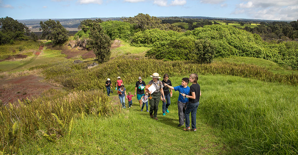 Park Ranger Jessica leads a family on a hike to the top of Pu‘u o Lokuana cindercone in the Kahuku Unit of Hawai‘i  Volcanoes National Park.
