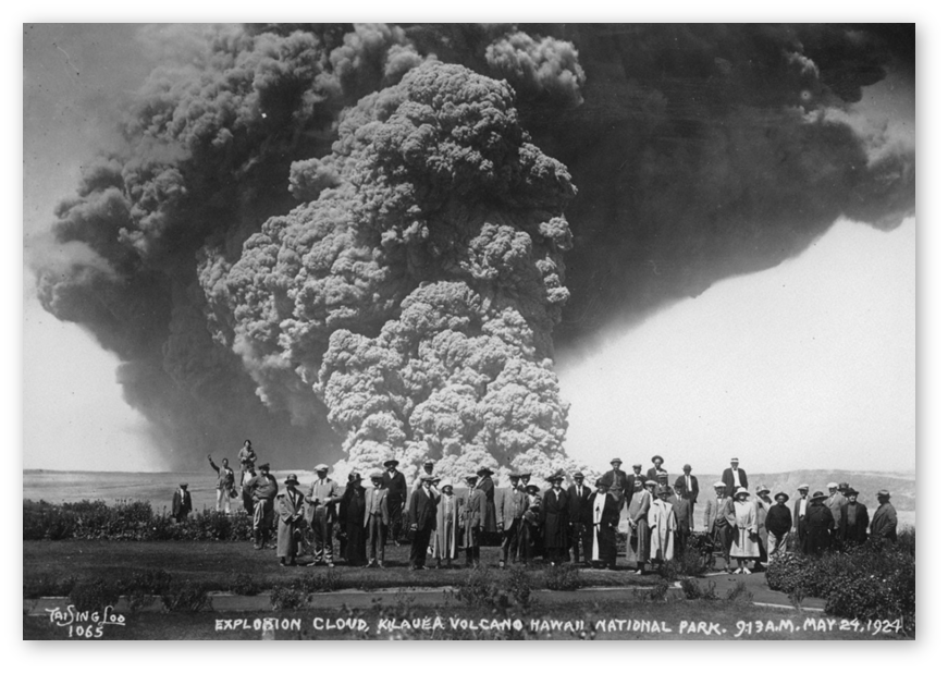 Tai Sing Loo explosion courtesy Bishop Museum 1924 Black and white photo of a crowd of people standing in front of an explosive volcano with a huge cloud of gas and ash billowing behind them upward