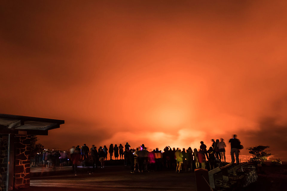 Visitors eager to see the lava lake within Halema‘uma‘u Crater at the summit of Kīlauea Volcano gather along the overlook at Jaggar Museum in Hawai‘i Volcanoes National Park