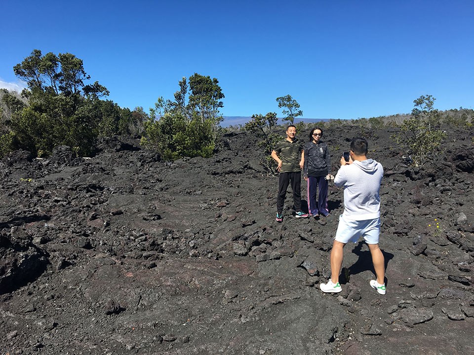 Visitors from China on pose for photos on lava fields