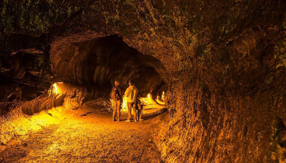 A family explores the interior of Nāhuku during the illuminated hours A family explores the interior of Nāhuku during the illuminated hours