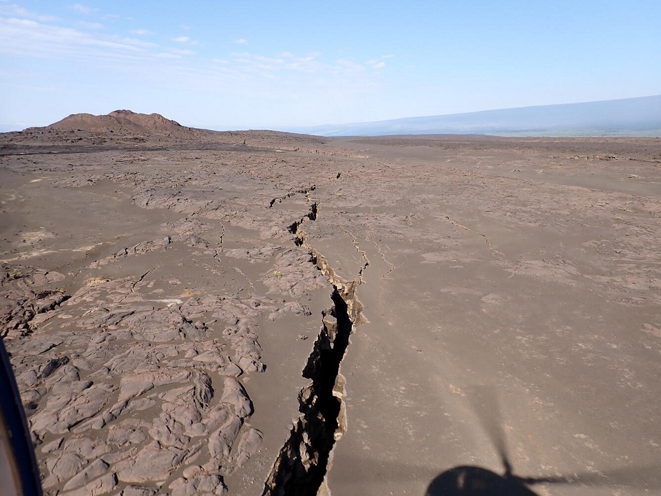 lr-USGS June 6 2024 Large wide earth crack towards Pu'u Koa'e USGS HVO Aerial of a large nearly formed earth crack snaking across a desert like landscape