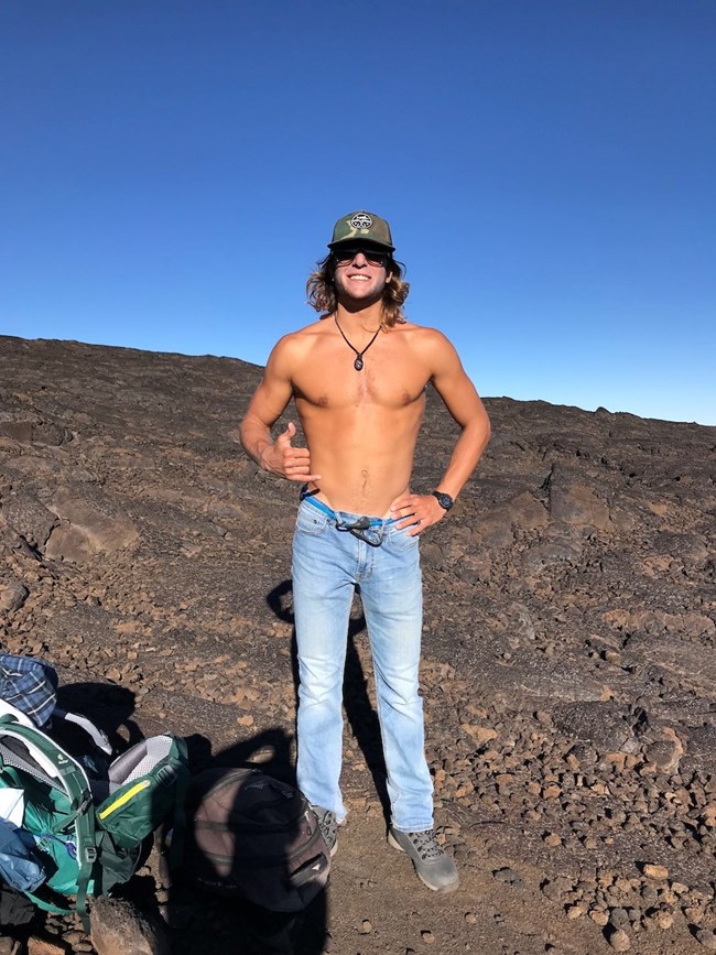Shirtless man standing in lava fields