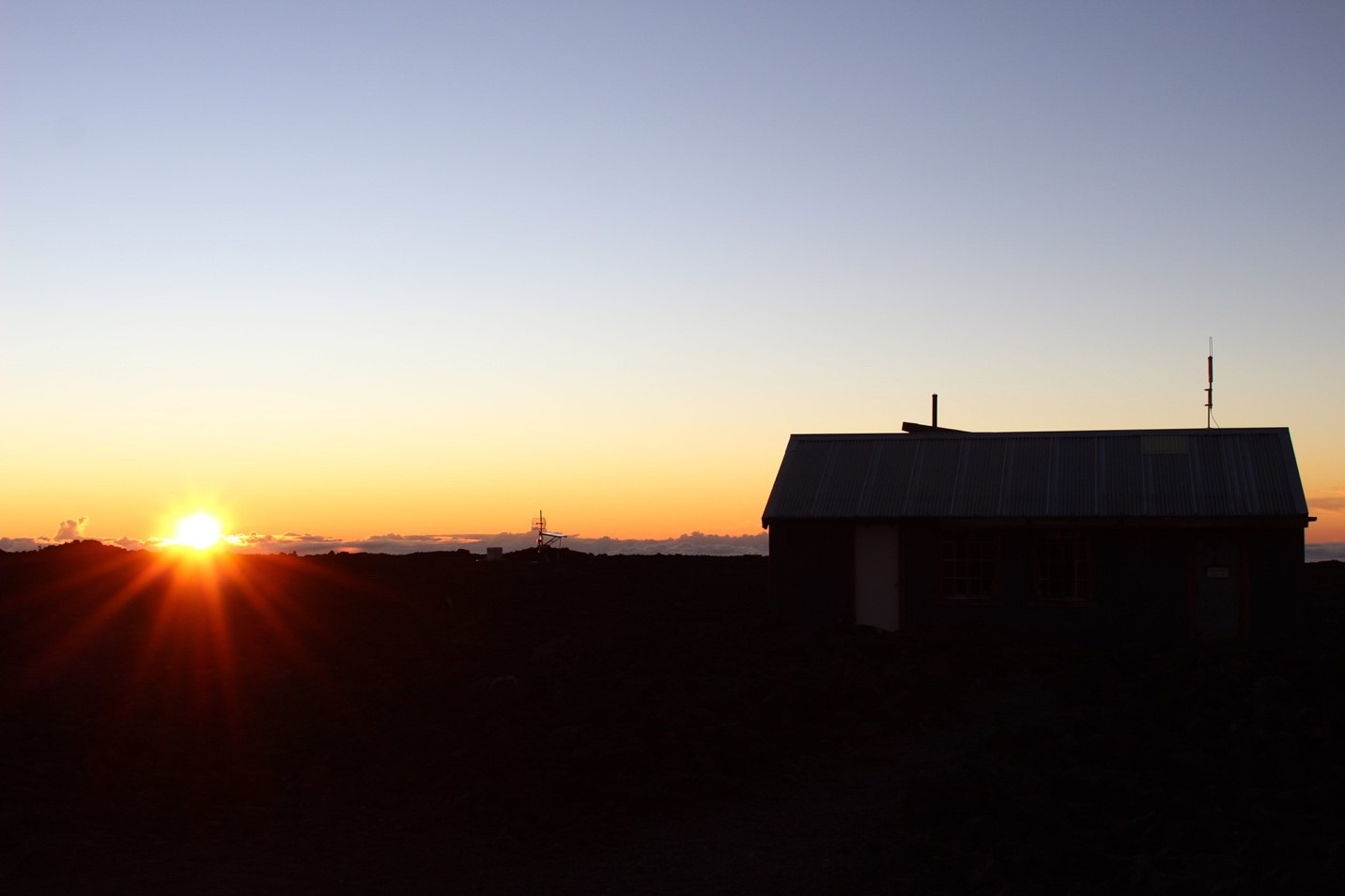 Sunrise over the silhouette of a cabin