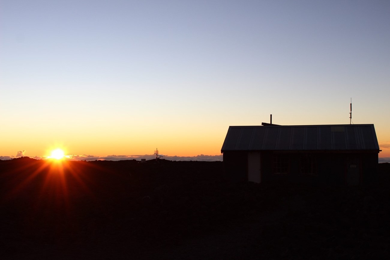 Sunrise over the silhouette of a cabin