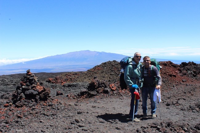 Two hikers posing in a lava field