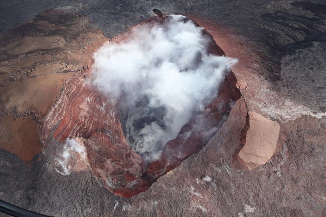 Crater walls expose a clear sequence of red lava flows and cinder that built the cone in the early 1980s.