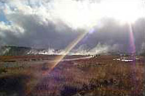 Sunlight streams through the clouds along the roadway with steaming vents in the background. Sunlight streams through the clouds along the roadway with steaming vents in the background.