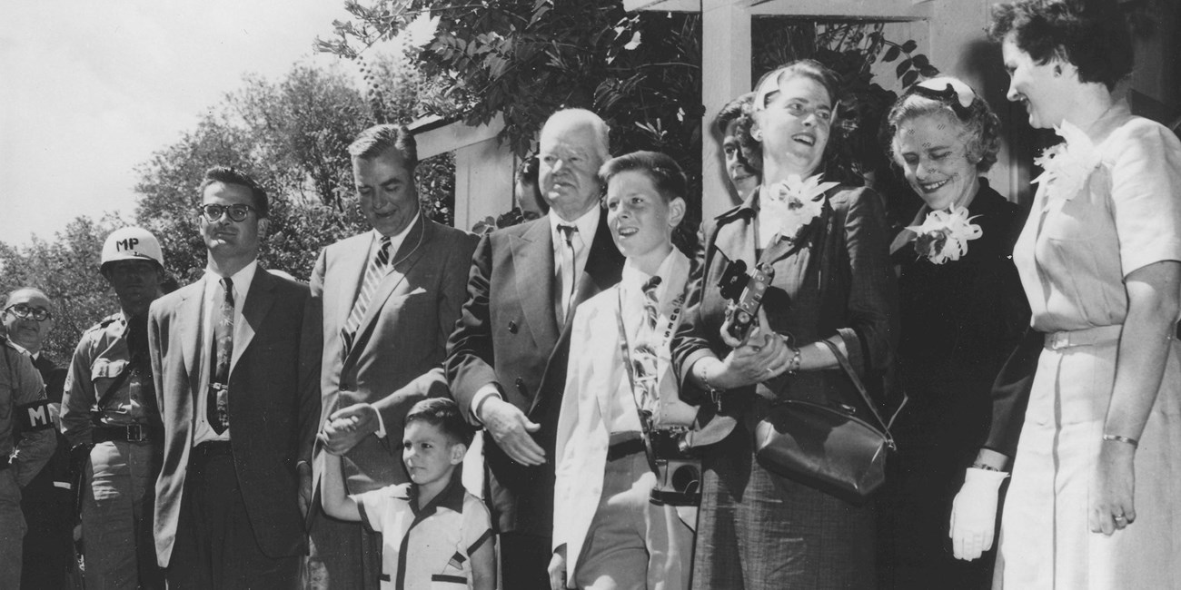 Four generations of a family poses in front of a historic house in 1954.