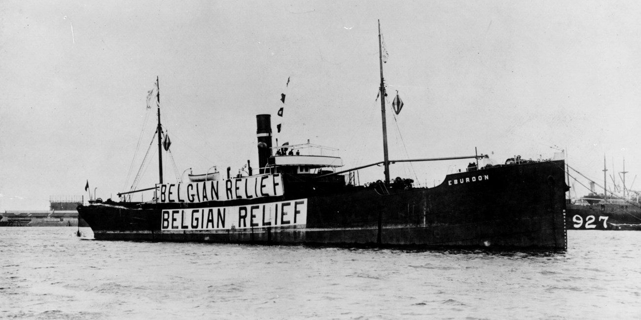 A cargo ship displays banners reading Belgian Relief.