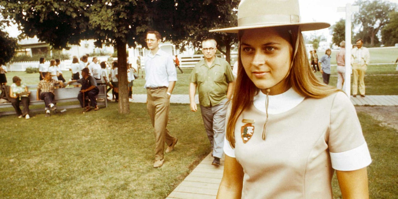 A 1970s photo depicts park visitors following a female ranger in a tan uniform.