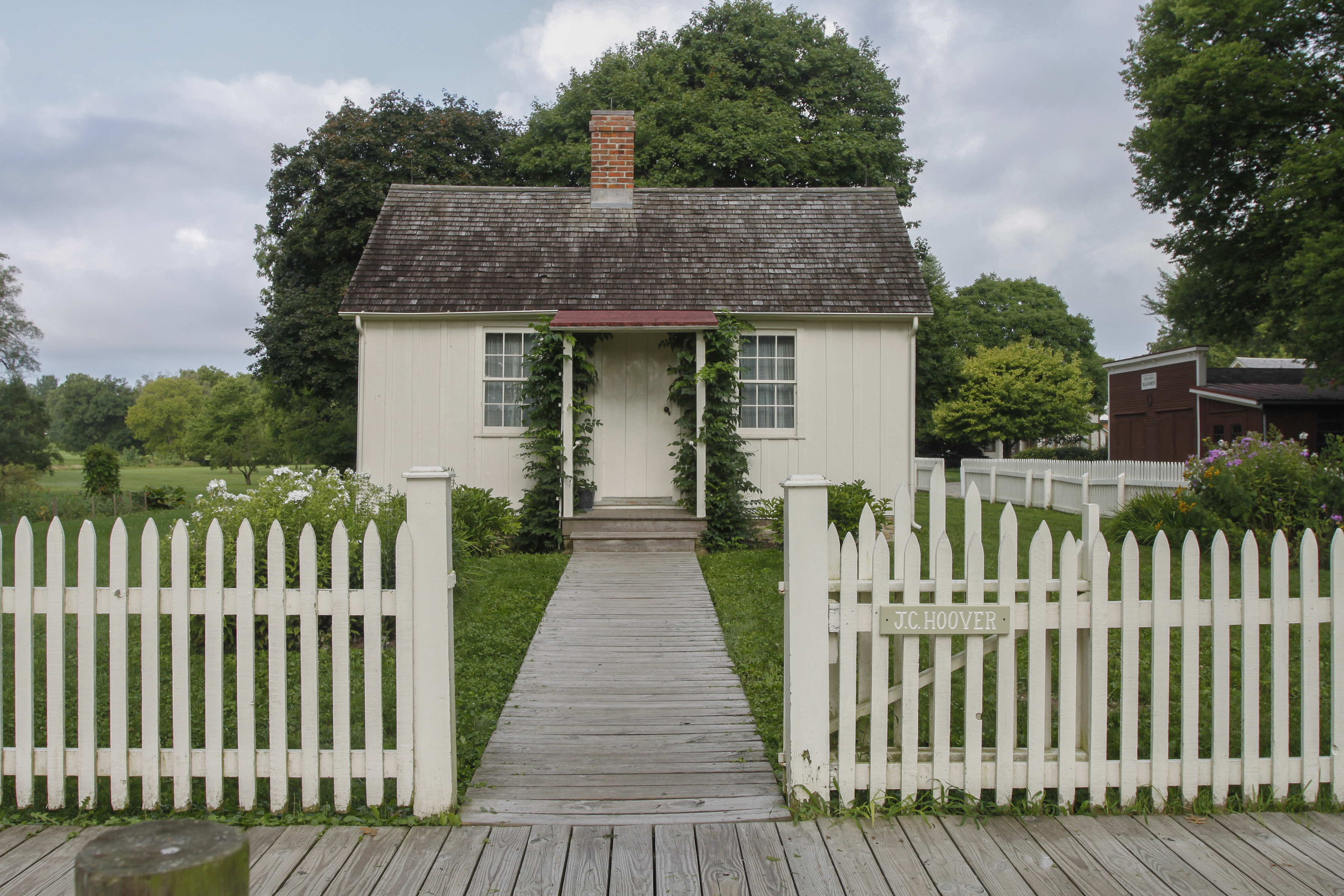 White cottage with picket fence surrounding it