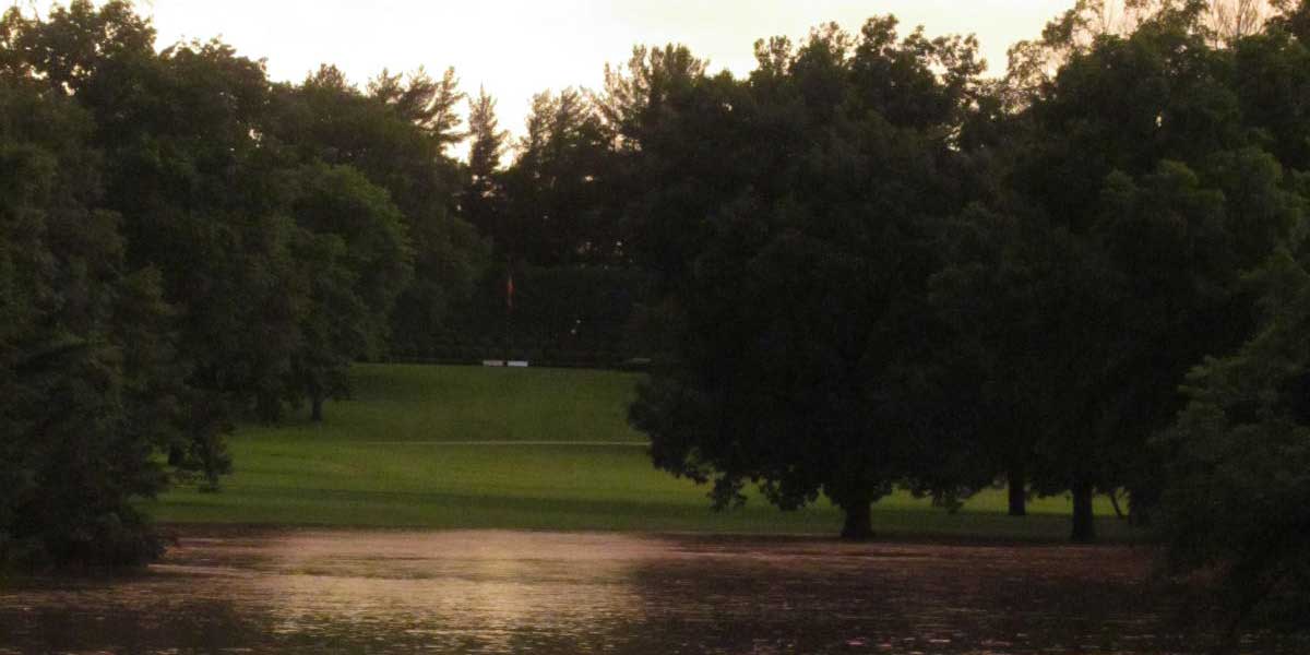 A presidential gravesite overlooks a flooded park at sunset.