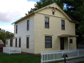 A yellow two story house with brown trim.
