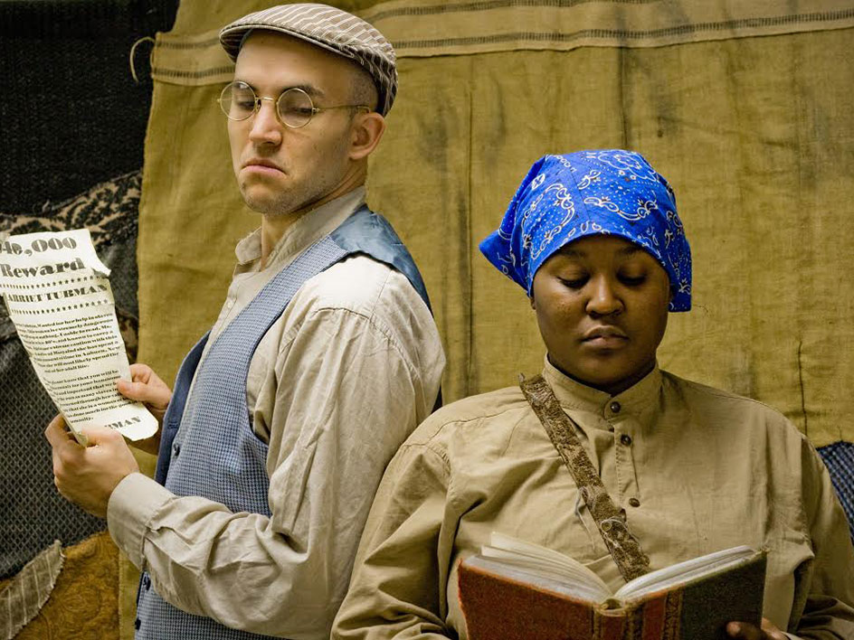Bright Star Touring Theater's Heroes Of The Underground Railroad Stage actors in 19th century dress portray a white man and a black woman.