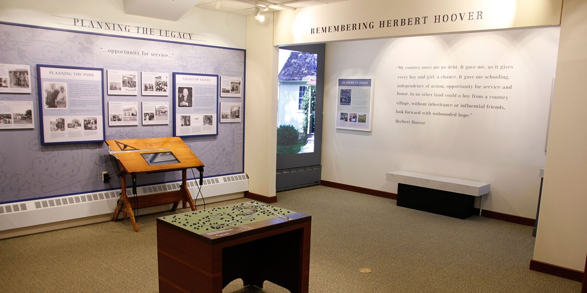 Exhibits line the walls of a small museum room. Exhibits line the walls of a small museum room.