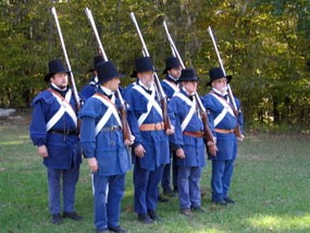 living history volunteers preparing to fire