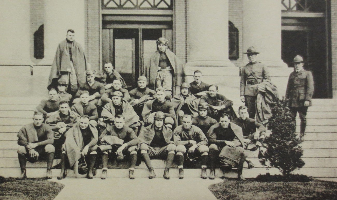 Football players sitting on the steps to a building