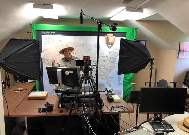 a ranger poses in front of computer equipment.