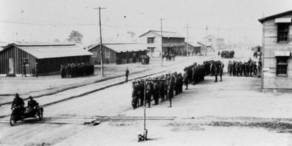 Soldiers standing at attention in front of camp buildings Soldiers standing at attention in front of camp buildings