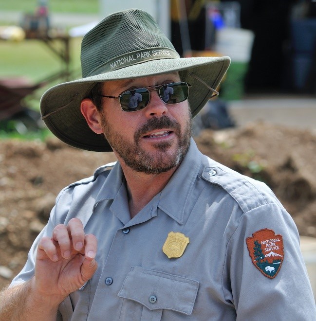 Uniformed NPS archeologist male with hat and sunglasses.