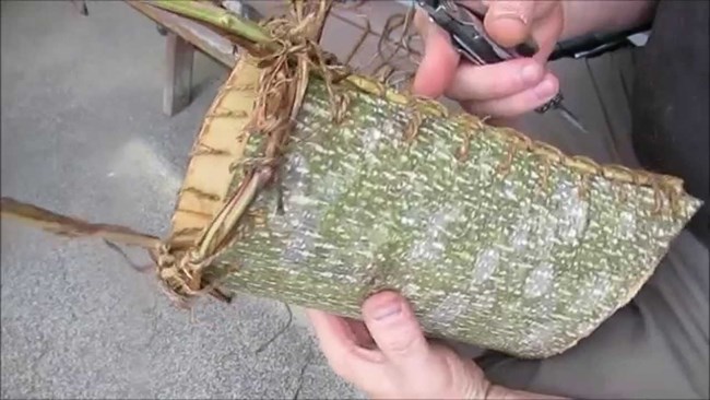 human hand holding a tree bark basket.