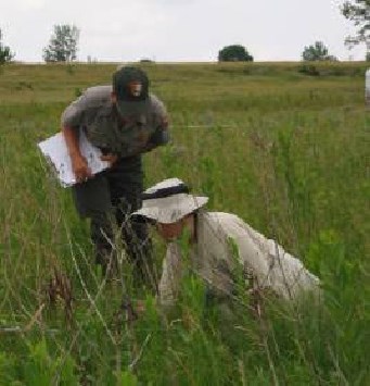 A volunteer helps national park staff inventory grassland species. Photo from NPS Heartland Network. A volunteer helps national park staff inventory grassland species. Photo from NPS Heartland Network.