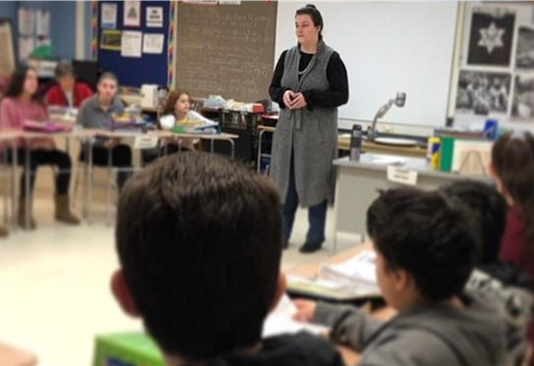 A woman stands in front of a group talking