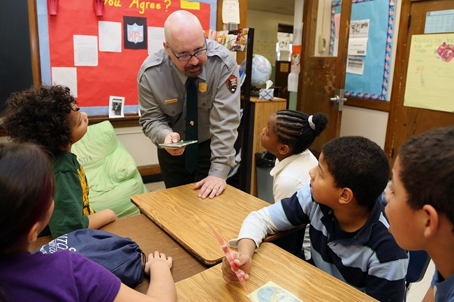 A ranger talks to a group of kids in their class.