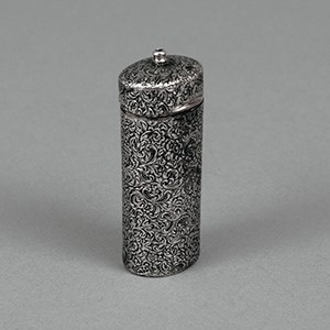 A silver match case in cylindrical form with floral decoration.