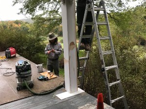 Two Park Rangers repairing a wooden porch.