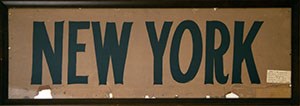 A framed card stock sign with "NEW YORK" in bold black letters.