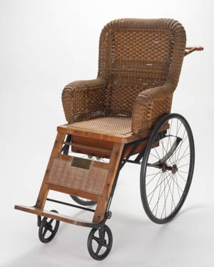 A wicker and wood invalid chair