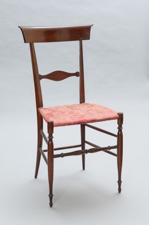 A delicate wood side chair with curved slat and damask upholstered seat.