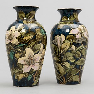 A pair of vases decorated with painted lillies.