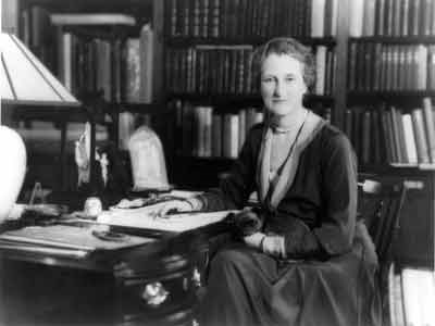 A photograph of Beatrix Farrand seated at a desk.
